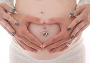 Piercing enceinte sur un ventre de grossesse