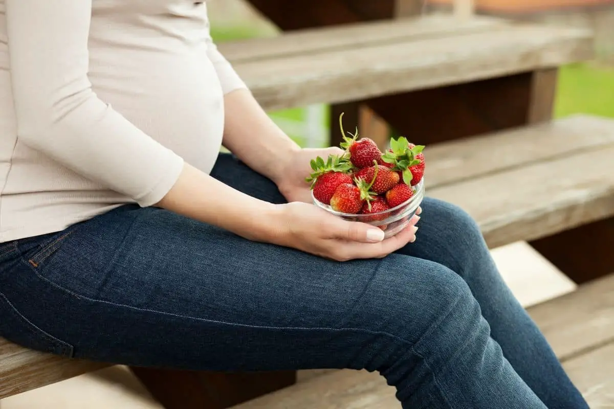 Femme mangeant des fraises pendant la grossesse