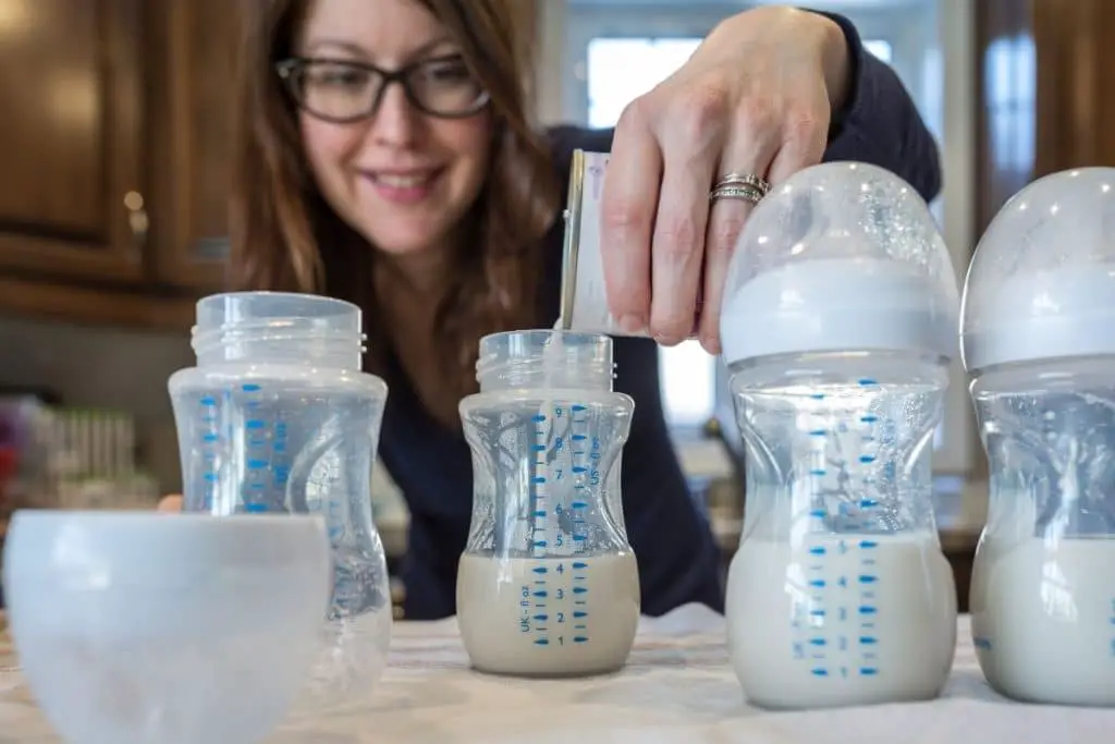 Maman en train de préparer des biberons de lait infantile