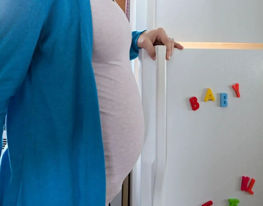 Femme enceinte devant son réfrigérateur