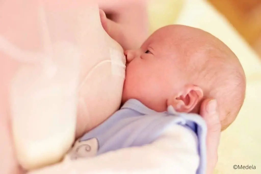 Bébé allaité avec un dispositif d'aide à la lactation