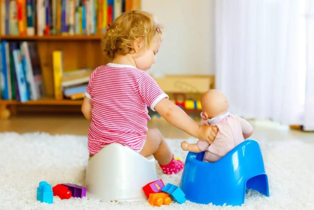Bébé et baigneurs tous les deux sur un pot pour l'apprentissage de la propreté