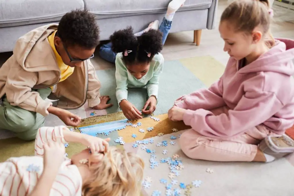 Enfants en train de faire un puzzle ensemble